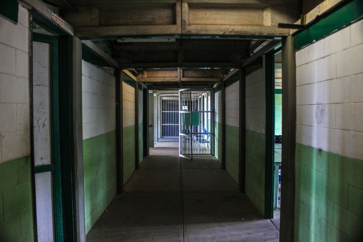 Corridoio vuoto di un istituto penitenziario con celle aperte