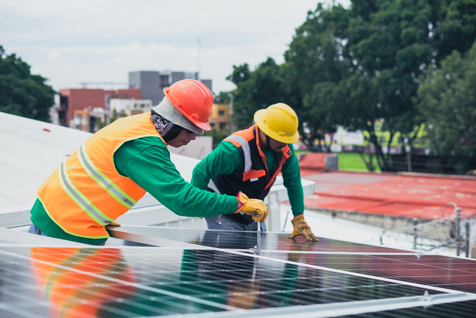 Tecnico installa pannelli fotovoltaici su un tetto industriale, impianto solare per accumulo commerciale