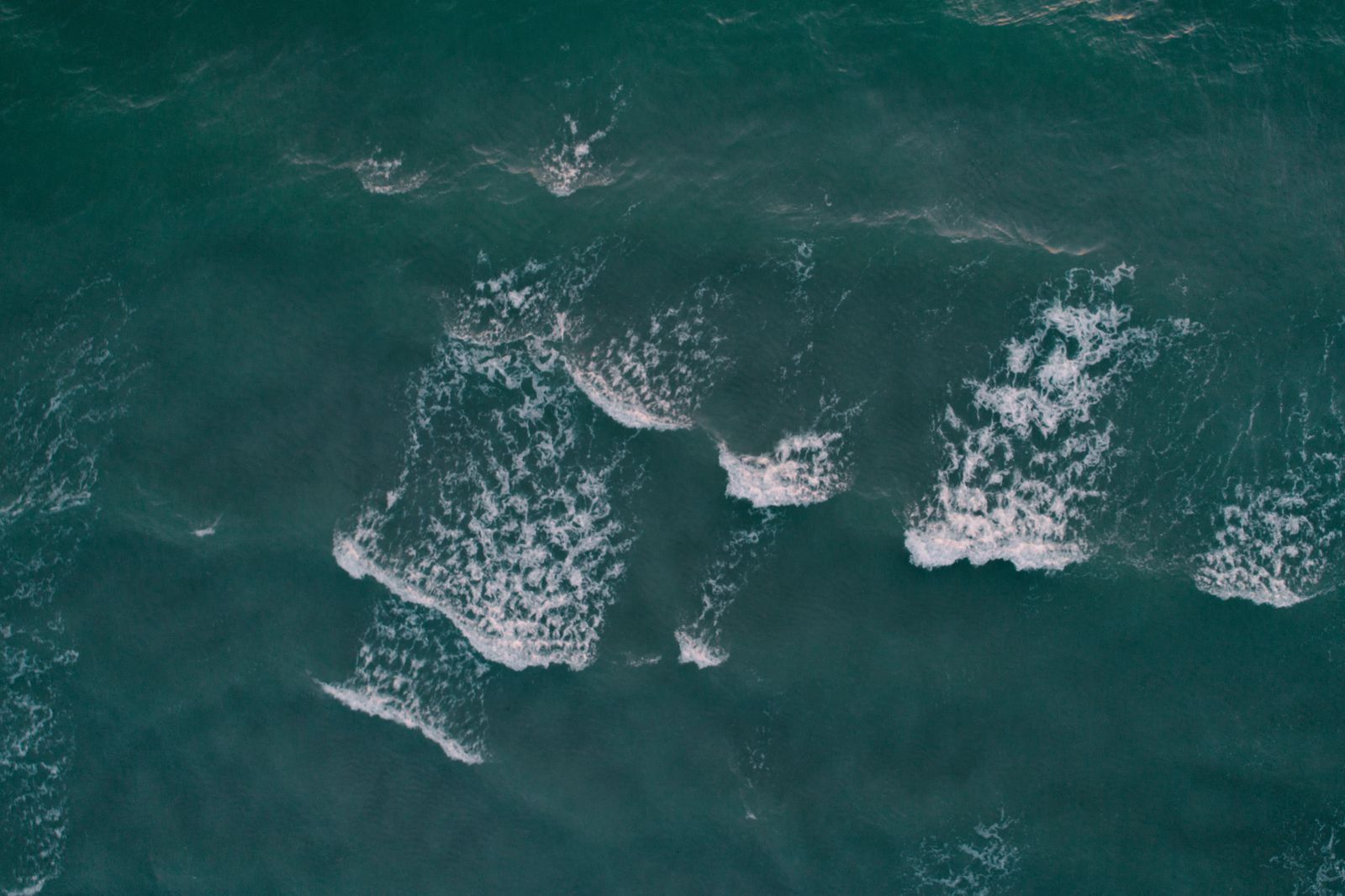 Vista aerea di onde oceaniche, l'acqua di mare come risorsa per idrogeno e dissalazione