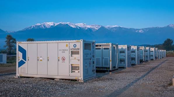 Tecnico ispeziona batterie in un magazzino industriale, accumulo energetico su scala