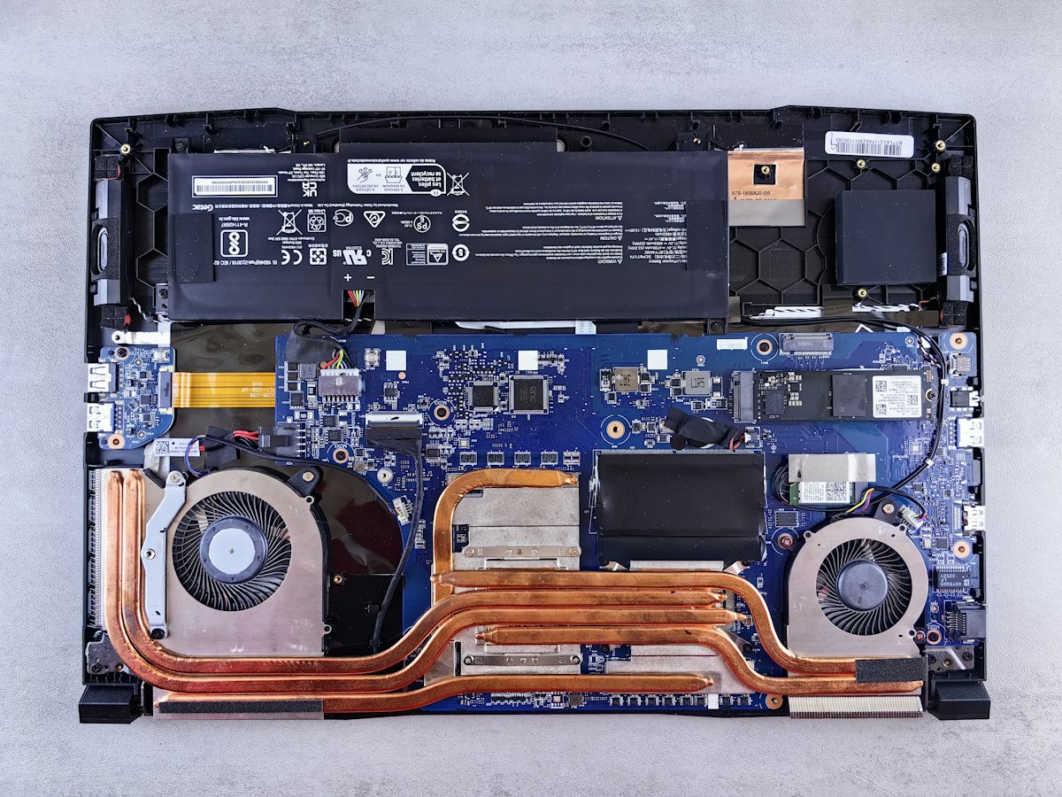 Interno di un notebook con batteria, scheda madre, dissipatori in rame e ventole
