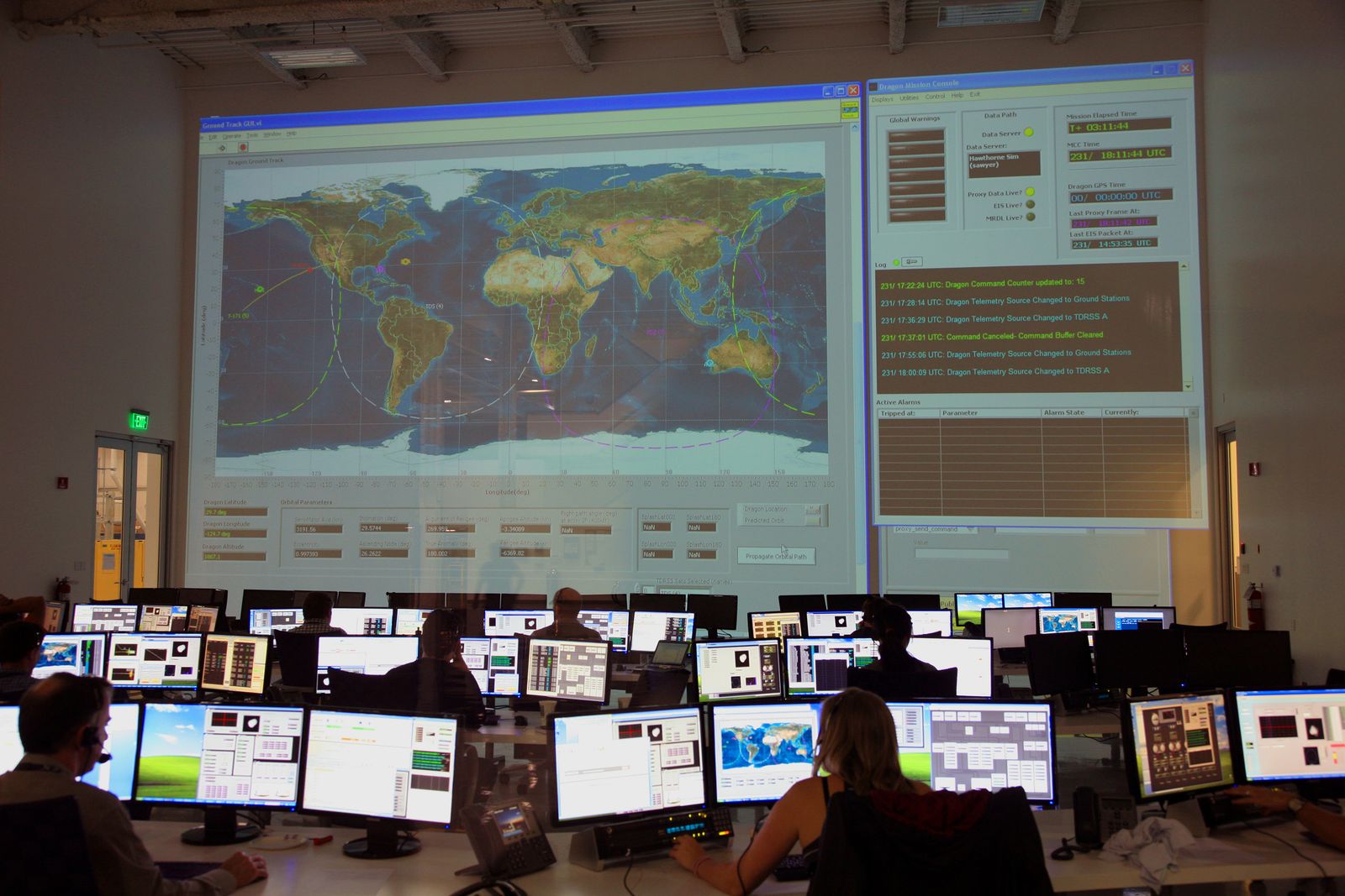 Sala operativa con grande mappa interattiva a parete e operatori al lavoro