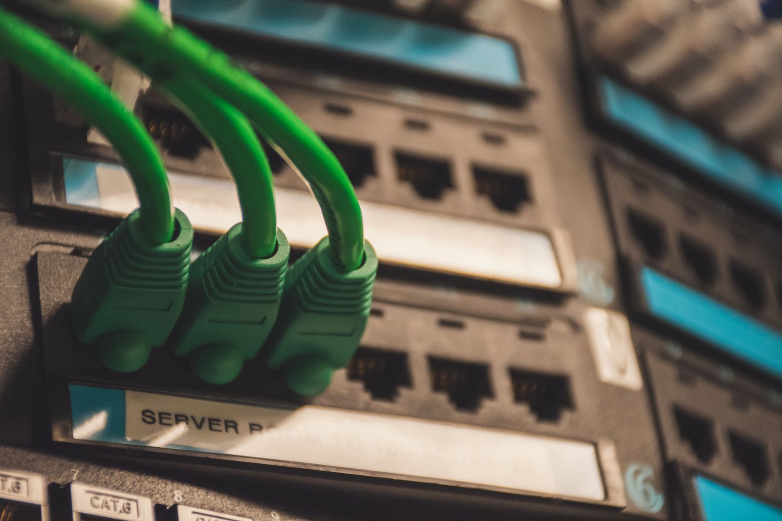 Primo piano di cavi di rete collegati a porte server, a rappresentare l'infrastruttura di un registro distribuito enterprise