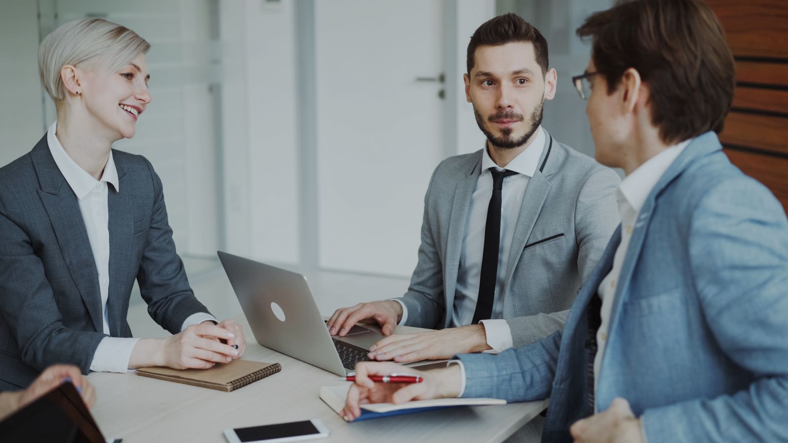 Manager e team aziendale in una sala riunioni moderna durante un'analisi di dati e intelligenza artificiale