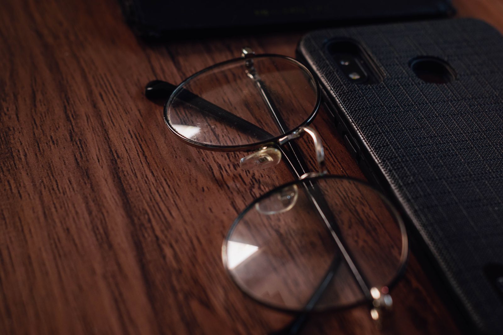 Occhiali da vista accanto a uno smartphone, a rappresentare l'abbinamento tra occhiali intelligenti e telefono