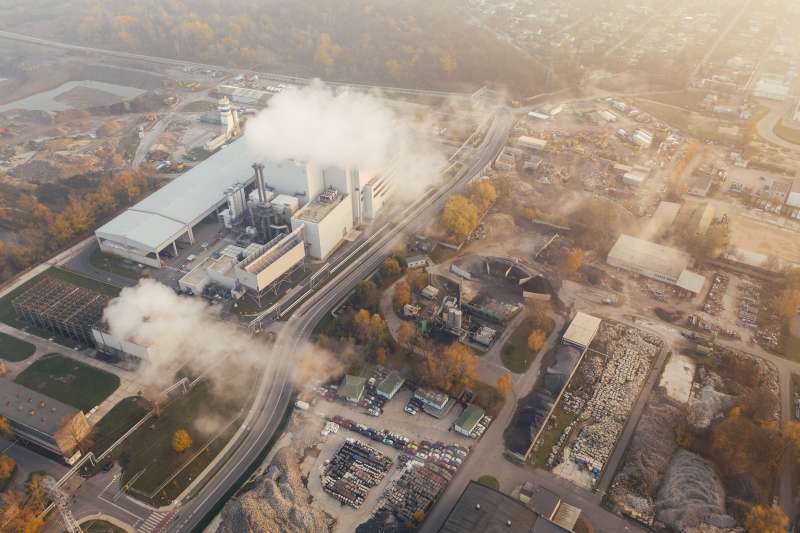 Vista aerea di un impianto industriale con vapore e fumo bianco in uscita dalle torri