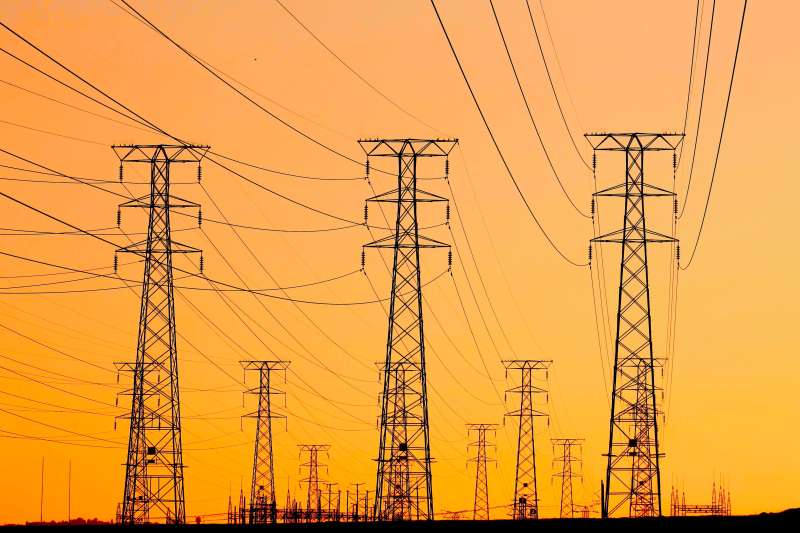Traliccio dell'alta tensione con linee elettriche al tramonto