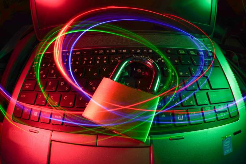 Lucchetto appoggiato sulla tastiera di un computer portatile con scie di luce, simbolo della protezione delle password aziendali