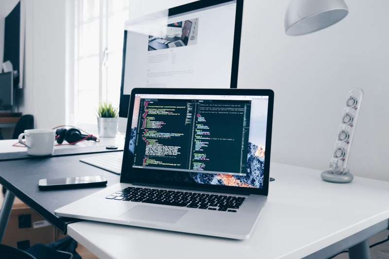 Computer portatile su una scrivania con il codice di un sito web aperto nell'editor, immagine simbolica dell'aggiornamento di un sito aziendale a Joomla 6.2