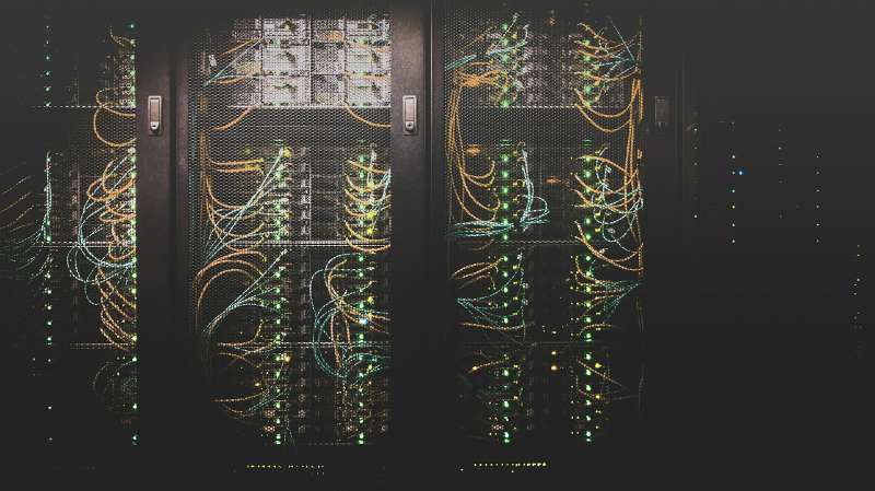 Armadi rack di un data center con cavi di rete e luci dei server accese, immagine simbolica della migrazione di Monaco di Baviera da VMware a Proxmox