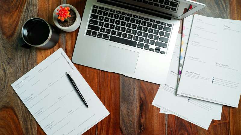 Computer portatile aperto su una scrivania in legno, simbolo del lavoro d'ufficio su documenti, fogli di calcolo e presentazioni