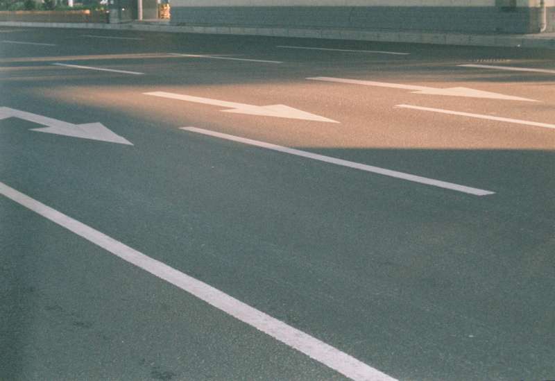 Strada asfaltata cittadina in pieno sole, immagine simbolica della sperimentazione sui rivestimenti stradali riflettenti