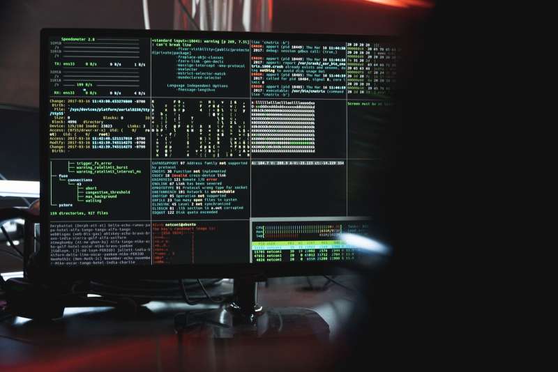 Monitor con codice informatico su schermo scuro, simbolo di una vulnerabilita di sicurezza software