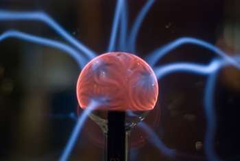 Primo piano di una sfera di plasma con scariche elettriche luminose, simbolo della fisica della fusione nucleare