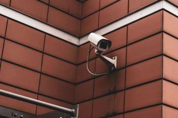 Telecamera di videosorveglianza fissata sulla facciata in mattoni di un edificio