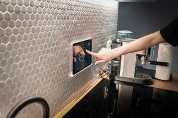 Pannello touch per il controllo della casa intelligente installato a parete in cucina
