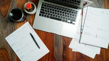 Computer portatile aperto su una scrivania in legno, simbolo del lavoro d'ufficio su documenti, fogli di calcolo e presentazioni
