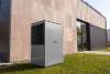 Unità esterna di una pompa di calore aria-acqua accanto a un edificio residenziale